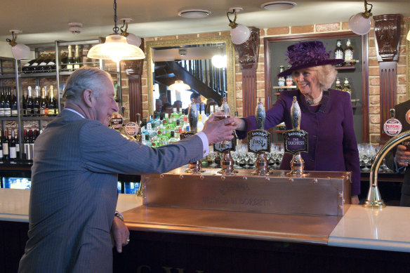 Camilla, the Duchess of Cornwall, serves Prince Charles a pint at one of Poundbury’s two pubs.