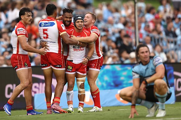The Dolphins celebrate a try as Nicho Hynes looks on.