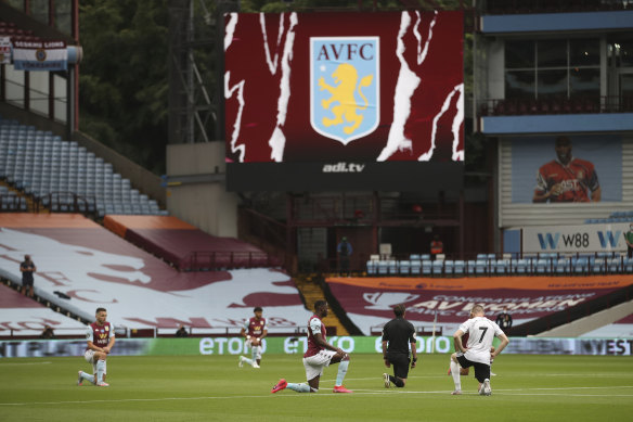 Players kneel before the start of the English Premier League soccer match between Aston Villa and Sheffield United on Wednesday.