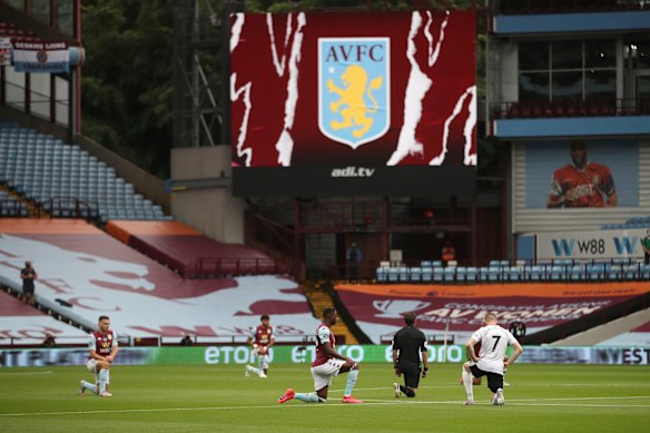 Players kneel before the start of the English Premier League soccer match between Aston Villa and Sheffield United on Wednesday.