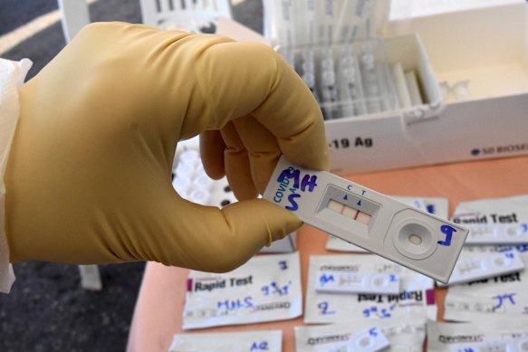 The split between the developing world and the developed world is on display: a medical technician displays a fast result COVID-19 tester at a mobile testing site in Tunis.