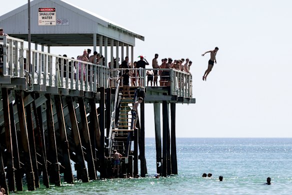 Os saltadores do cais escapam do calor em Adelaide na segunda-feira.