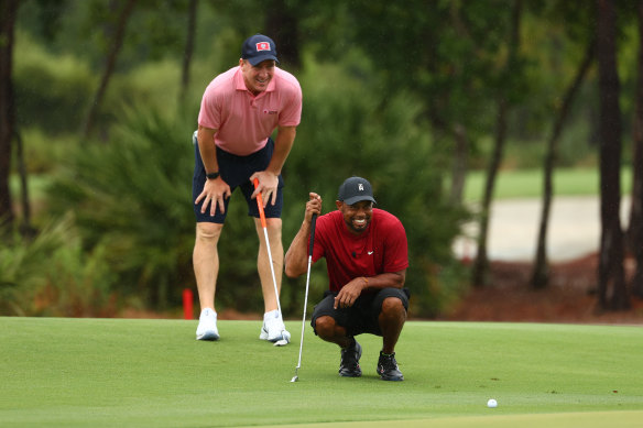 Peyton Manning gives his playing partner Tiger Woods some tips during their match-up against Tom Brady and Phil Mickelson in Florida.