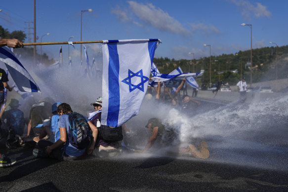 Israeli police use a water cannon to disperse demonstrators.