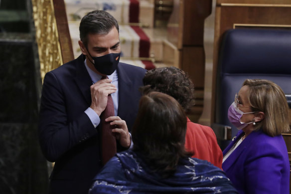 Prime Minister Pedro Sanchez adjusts his tie.
