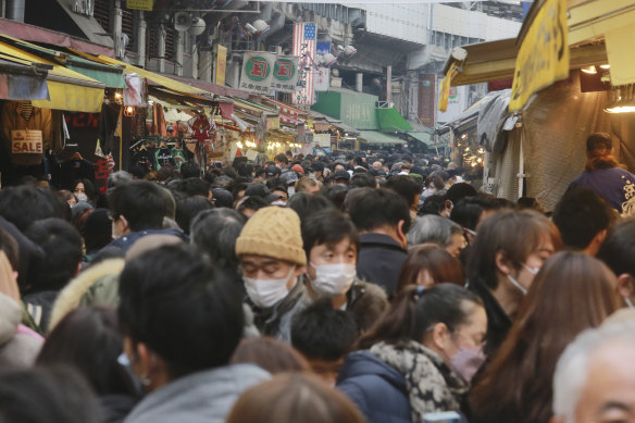 Yılbaşı gecesi Tokyo'da yıl sonu alışverişi sırasında insanlar bir caddeyi doldurur.