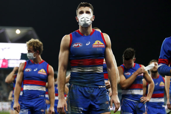 A masked Marcus Bontempelli leads the Bulldogs off the ground after the loss to the Cats.
