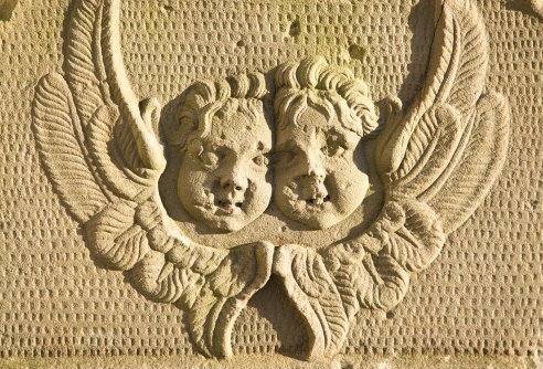 Two cherubs on a stone gravestone in a graveyard in Suffolk, England.