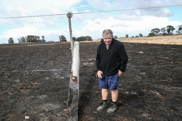 Jack Kenna inspects a burnt-out power pole on his property at The Sisters. 