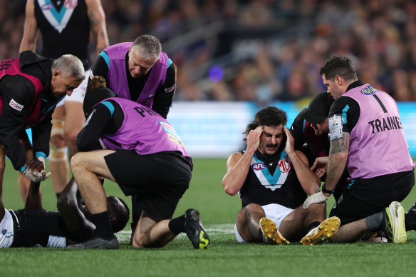 Port Adelaide teammates Aliir Aliir and Lachie Jones are treated after they were involved in a nasty collision against the Crows on Saturday night.