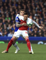 Everton's Lucas Digne and Arsenal's Mesut Ozil battle for the ball at Goodison Park.