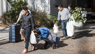 Residents leave Mascot Towers with some of their possessions.