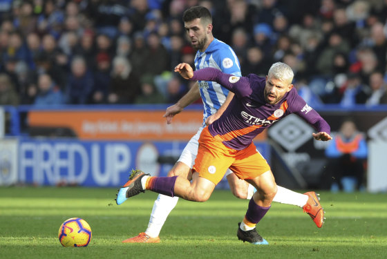 Manchester City's Sergio Aguero is tackled by Huddersfield's Tommy Smith.