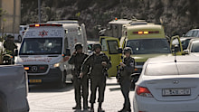 Israeli soldiers and emergency personnel gather near ambulances at a junction near Hebron in the occupied West Bank.