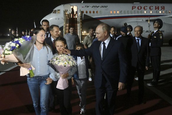 Russian President Vladimir Putin, foreground right, walks with released Russian prisoners and relatives upon their arrival at the Vnukovo government airport outside Moscow, Russia.