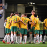Australia’s players celebrate Japan’s own goal at Saitama Stadium.