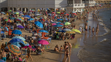 Tourists enjoy the beach in Cadiz, Spain, amid a spike in coronavirus cases.