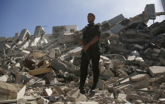 A policeman stands on the rubble of the media building destroyed by an Israeli airstrike.