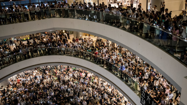 Protesters sing songs and shout slogans after gathering at the IFC Mall in Hong Kong on Thursday.