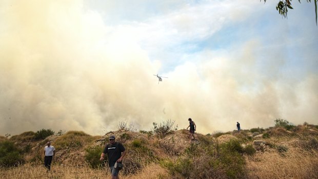 Residents observing the blaze run to safety after firefighting crews arrive to the scene.