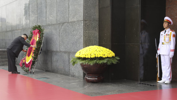 Kim adjusts a wreath during a ceremony at the Ho Chi Minh Mausoleum in Hanoi.