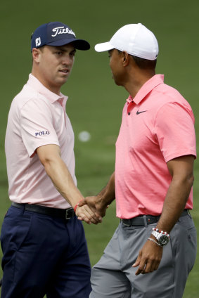 Warming up: Tiger Woods, right, greets Justin Thomas on the driving range.
