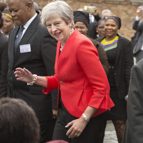 British Prime Minister Theresa dances with children during a visit to the ID Mkhize High School in Gugulethu, Cape Town, South Africa.