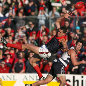 Brad Miller in the air as Geelong’s Jimmy Bartel goes by.
