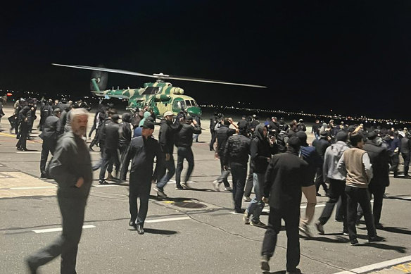 People in the crowd walk shouting antisemitic slogans at an airfield of the airport in Makhachkala, Russia.