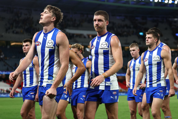 A dejected Kangaroos outfit leaves Marvel Stadium after their loss to Hawthorn.