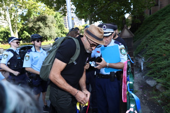 A man tries to remove ribbons from the St Mary’s Cathedral fence before the service.