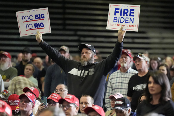 A supporter holds signs as Donald Trump speaks at a campaign rally in Greensboro, North Carolina last week.