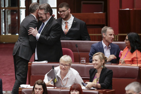 Greens leader Richard Di Natale and Senator Derryn Hinch embrace after the Senate agreed on amendments to  a bill in the Senate in February.