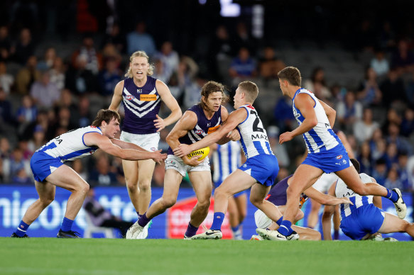 Nat Fyfe of the Dockers is tackled by George Wardlaw (L) and Tom Powell of the Kangaroos (R).