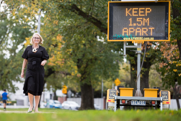 Melbourne lord mayor Sally Capp next to a sign urging social distancing.