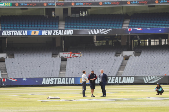 Officials chat in the centre of the ground. The pressure is on the MCG to produce a good pitch.