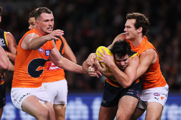 Darcy Fogarty of the Crows is tackled by Jack Buckley of the Giants.