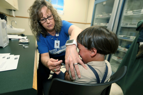 Kayıtlı bir hemşire ve bağışıklama sosyal yardım koordinatörü, 2019'da Mount Vernon, Ohio'da bir aşı uyguluyor.