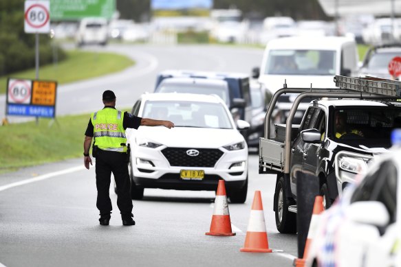 Vehicles arriving from NSW queue at a police checkpoint at the Queensland-NSW border in Coolangatta.