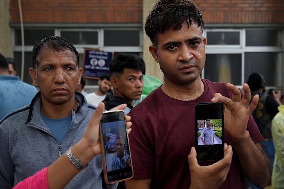 Raju Devkota (right) holds a photo of his brother Prakash Devkota, one of 10 to 12 members of his family who are missing from Rasuwa Kalika 4 Bhadaure village.