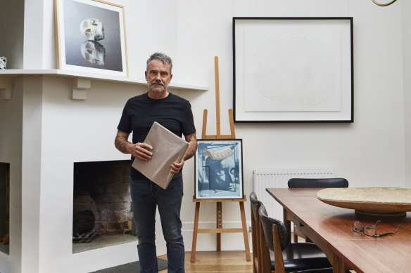 Carlo, an exhibiting artist for more than 30 years, in his light-filled dining room. His own work, Sleep, is on the mantel, a Geoff Nees papercut dominates the wall and, on the easel, is a collage by the late Hugh Kroll.