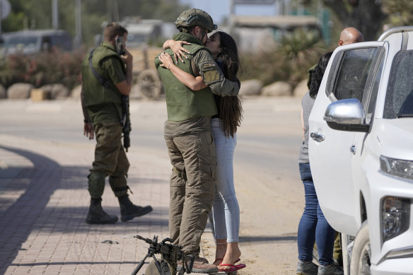 An Israeli soldier kisses his partner as she visits him near the border with the Gaza Strip.