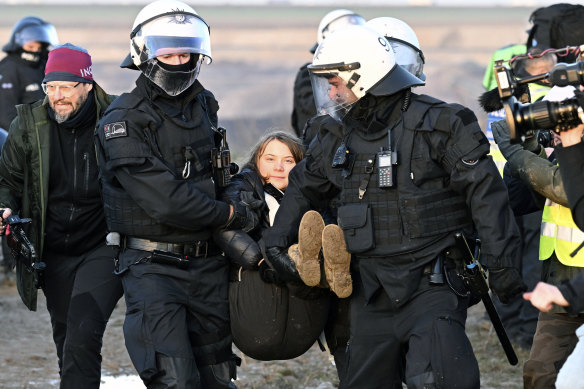 Police officers carry Swedish climate activist Greta Thunberg away.