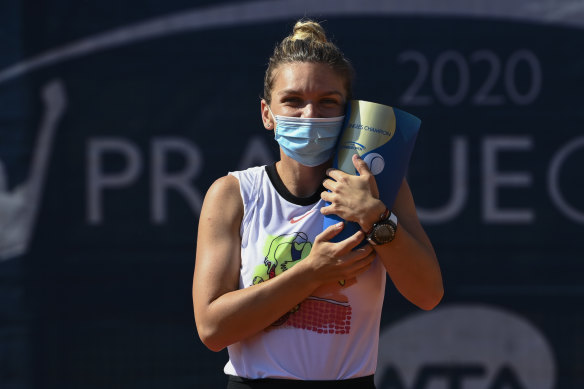 Simona Halep celebrates with the Prague Open trophy after victory in her first tournament since the coronavirus shutdown. She will not travel to the US but stay in Europe.