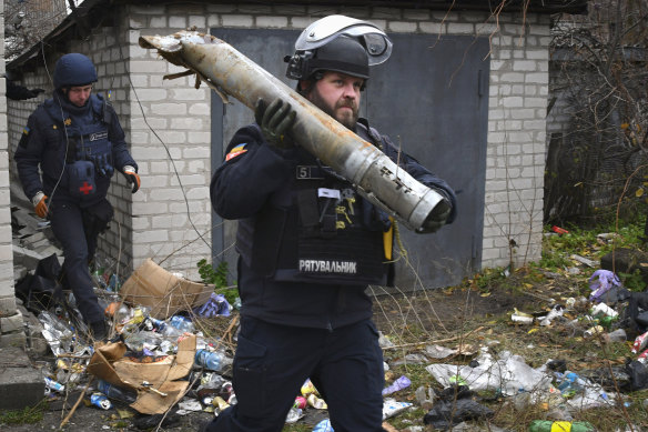 A Ukrainian sapper carries a part of a projectile during a demining operation in a residential area in Lyman, Donetsk region, Ukraine.