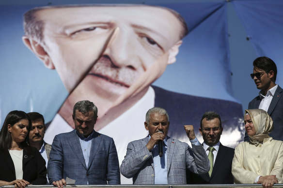 Backdropped by a poster of Turkey's President Recep Tayip Erdogan, Binali Yildirim (centre) mayoral candidate for Istanbul from Turkey's ruling Justice and Development Party, AKP, talks to supporters during his last election rally, in Istanbul.