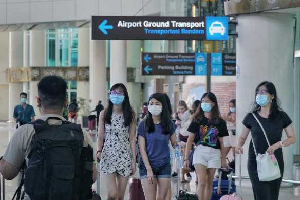 Passengers wear masks in the arrival hall of Bali's Denpasar airport.