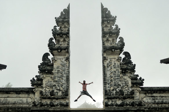 A tourist poses at the Lempuyang Temple in Bali.