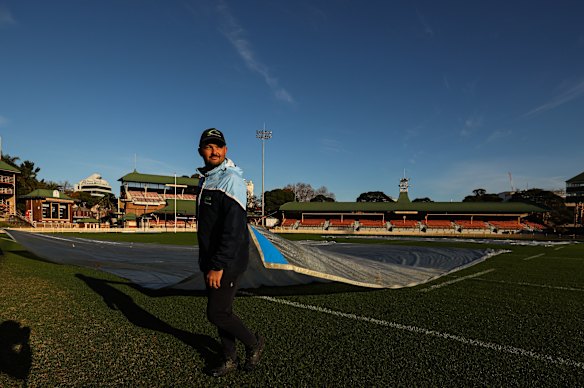 Shaun Eaton removes covers from the North Sydney Oval.