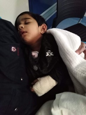 Two-year-old Tharunicaa, photographed in her father's arms after surgery to remove four of her teeth.